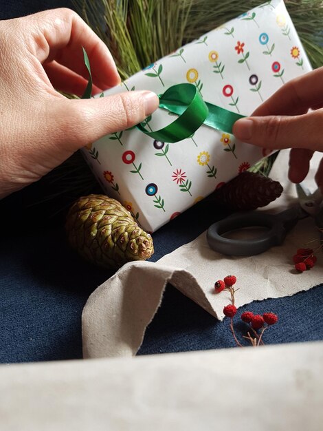 Photo cropped hands of person holding gift on table