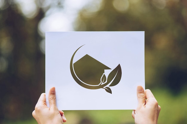 Photo cropped hands of person holding paper with model home and leaf cut out