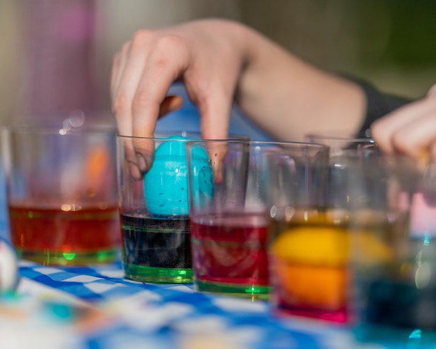 Cropped hands of person preparing easter eggs on table