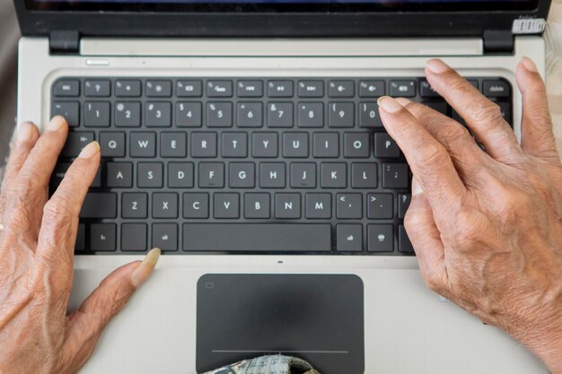 Photo cropped hands of person using laptop