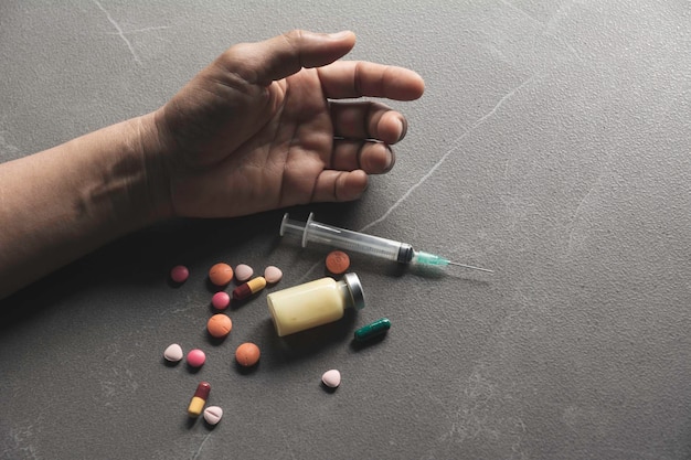 Cropped hands of person with medicines on floor