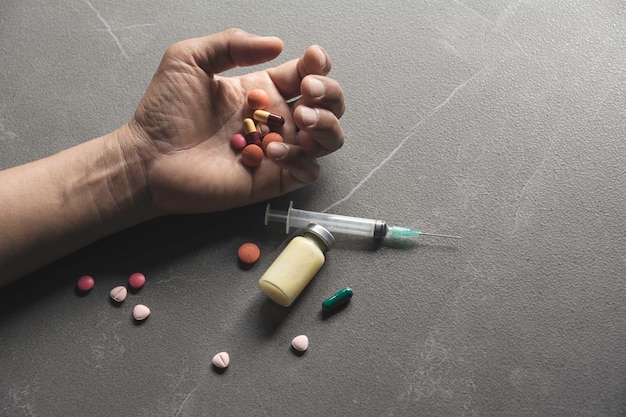 Photo cropped hands of person with medicines on floor