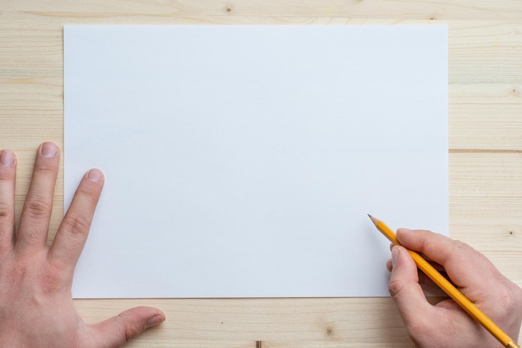 Photo cropped hands of person with pen and paper on table