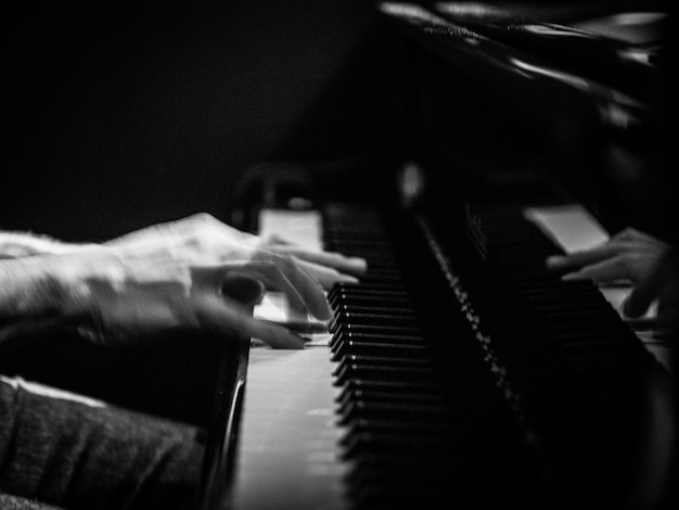 cropped hands playing piano