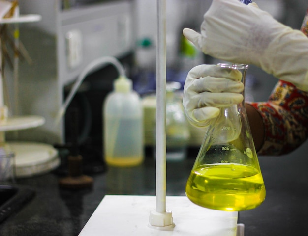 Cropped hands of scientist examining chemical at laboratory