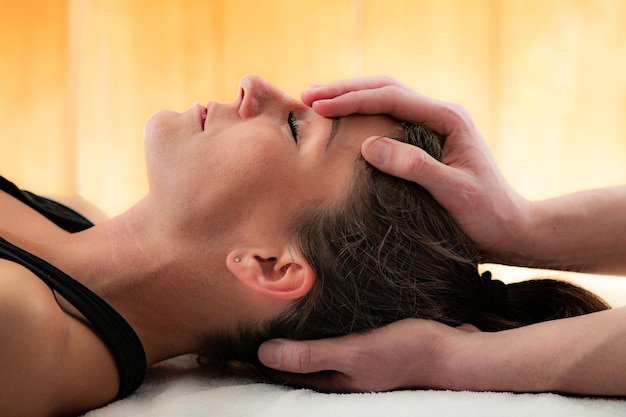 Photo cropped hands of therapist massaging woman head in spa