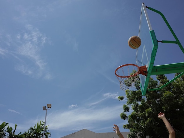 사진 손을 잘라서 하늘을 향해 농구를 던지고 있습니다.