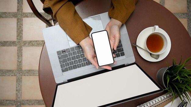 Photo cropped hands using laptop on table