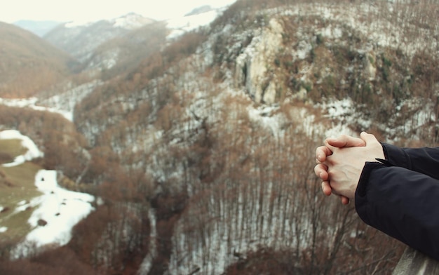 Foto mani tagliate di una donna contro le montagne durante l'inverno