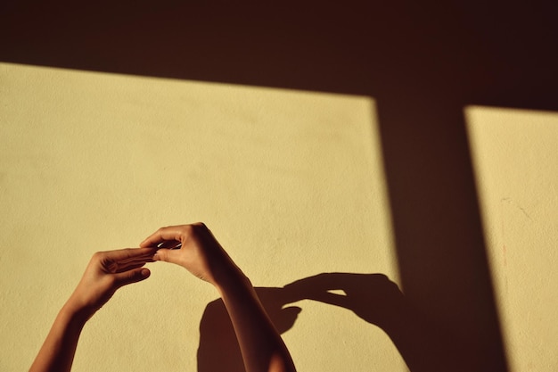 Cropped hands of woman against wall