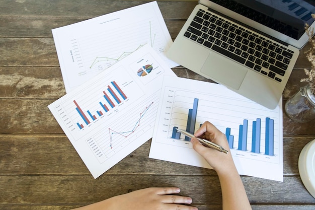 Photo cropped hands of woman analyzing graphs on table