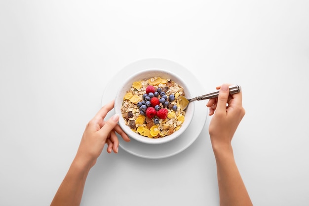 白い背景で朝食を食べている女性の手を切り取った
