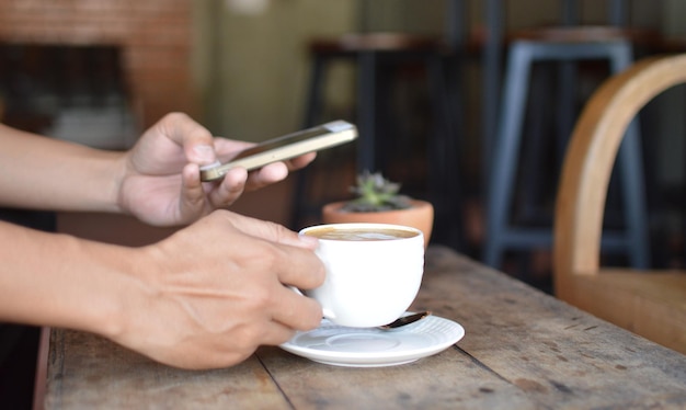 cropped hands of woman having coffee on table