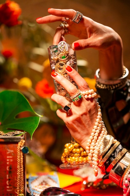 Cropped hands of woman holding champagne flute with jewelry