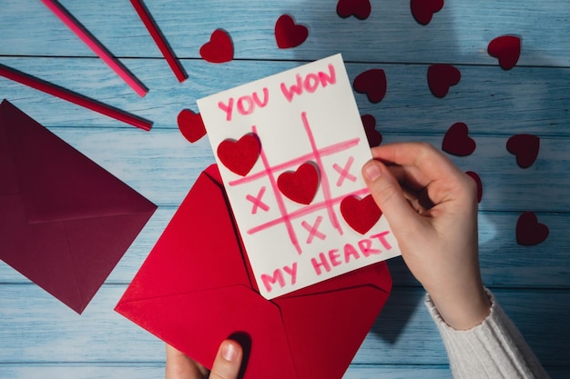 Foto mani tagliate di una donna che tiene la carta sul tavolo