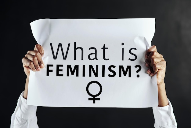cropped hands of woman holding paper with text against black background