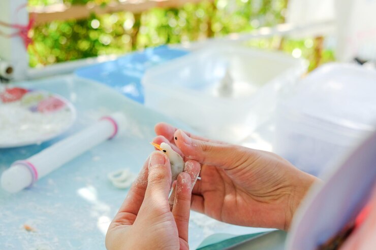 Photo cropped hands of woman making decoration on table