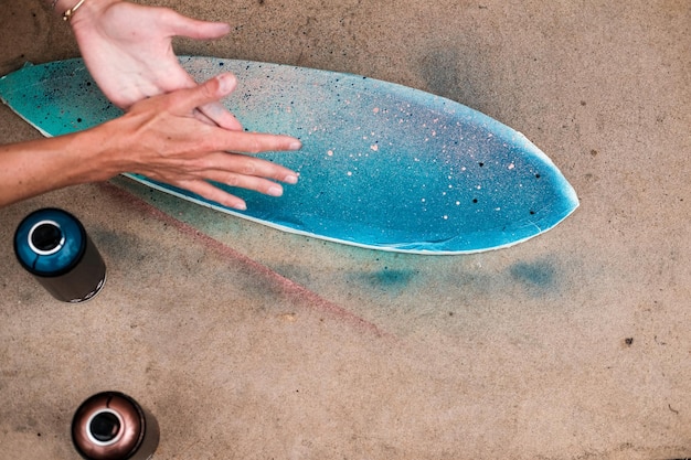 Foto mani tagliate di una donna che dipinge uno skateboard