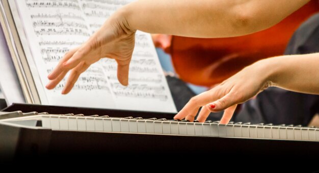 Foto mani tagliate di una donna che suona il pianoforte