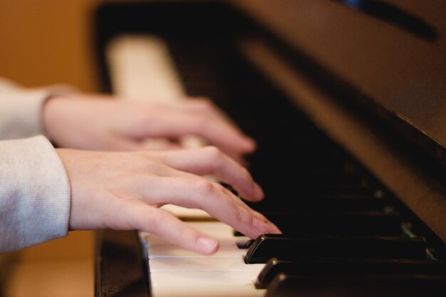 Cropped hands of woman playing piano