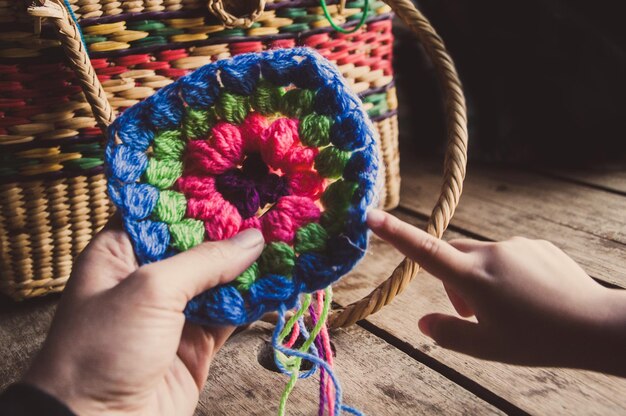 Foto mani tagliate di una donna che indica la lana a maglia