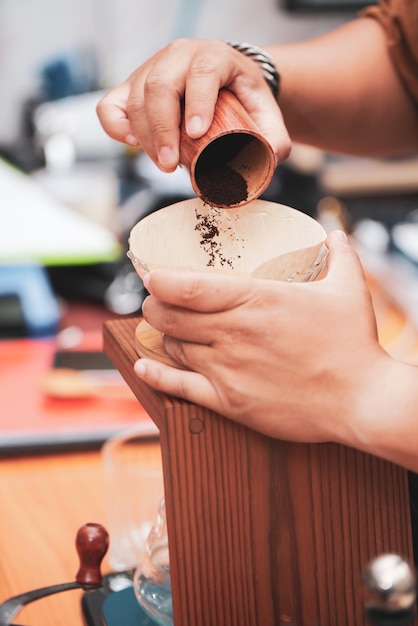 Photo cropped hands of woman pouring coffee powder in container