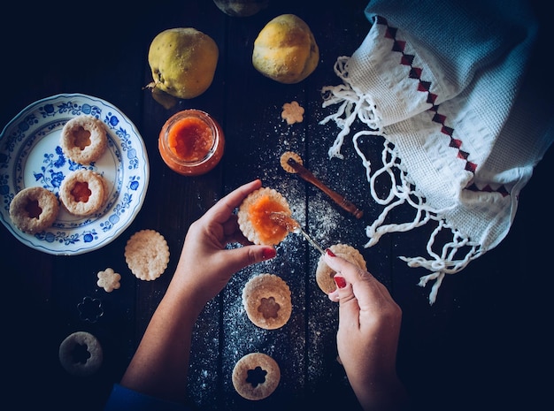 Photo cropped hands of woman preparing cookie on table