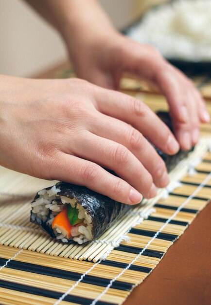 Foto mani tagliate di una donna che prepara il sushi a casa