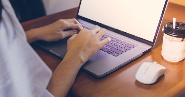 Photo cropped hands of woman using laptop at home