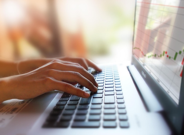 Photo cropped hands of woman using laptop at home