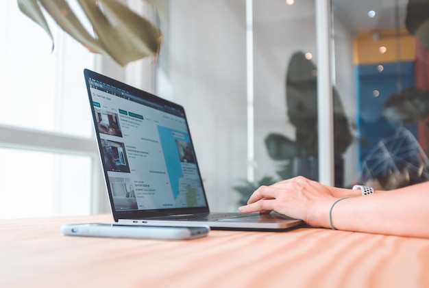 Photo cropped hands of woman using laptop on table