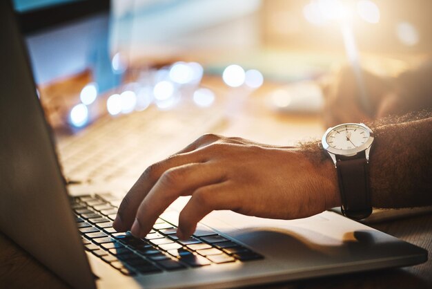 Photo cropped hands of woman using laptop