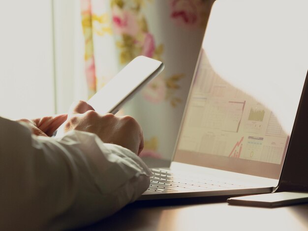 Photo cropped hands of woman using technologies at table