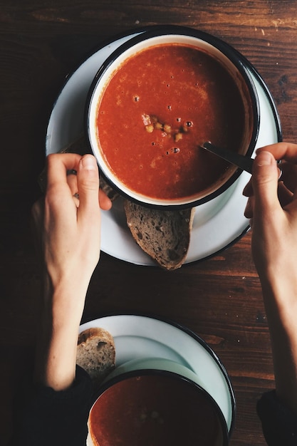 Photo cropped hands on woman with fresh soup on table