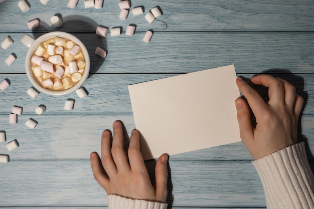 cropped hands of woman writing in book on table