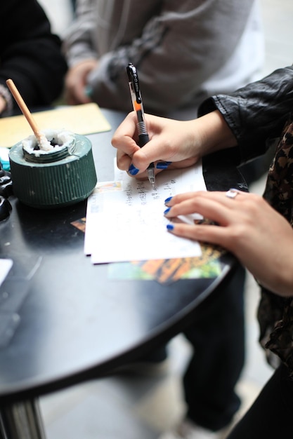 cropped hands of woman writing on paper