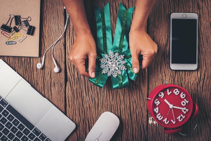 फोटो cropped hands of young woman making christmas decoration on wooden table