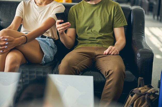 Cropped head of two people man and woman in casual clothes sitting on the black sofa in the indoors