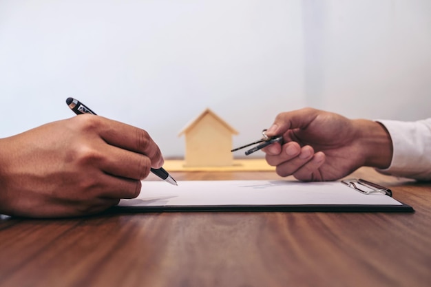 Cropped image of agent giving keys to customer