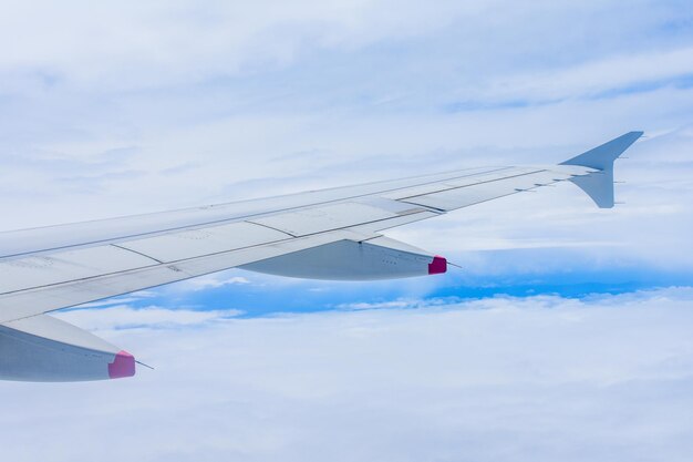 Photo cropped image of aircraft wing flying in sky