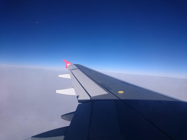 Photo cropped image of airplane against blue sky on sunny day