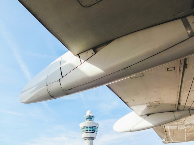 cropped image of airplane against control tower