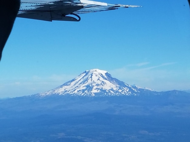 Cropped image of airplane against mountain and sky during winter