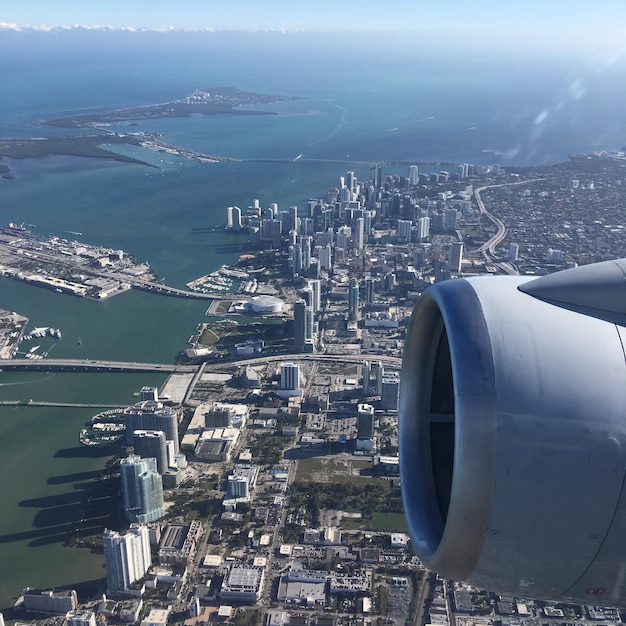 Foto immagine ritagliata di un aereo sopra il paesaggio urbano