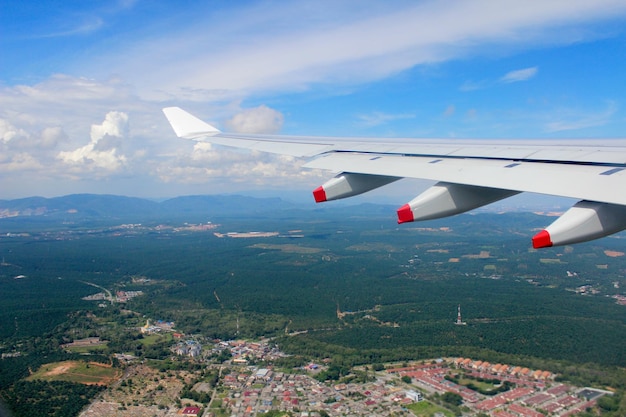 Foto immagine ritagliata di un aereo che vola sopra il paesaggio contro il cielo