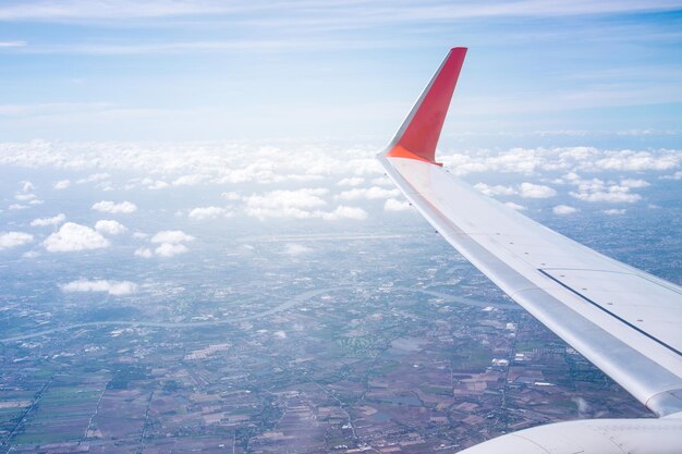 Cropped image of airplane flying over landscape against sky