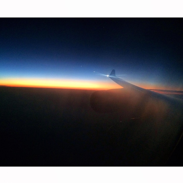 Photo cropped image of airplane flying over landscape