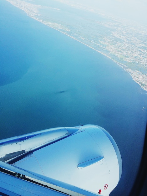 Foto immagine ritagliata di un aereo che vola sopra il mare