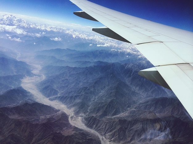 Cropped image of airplane wing over dramatic landscape