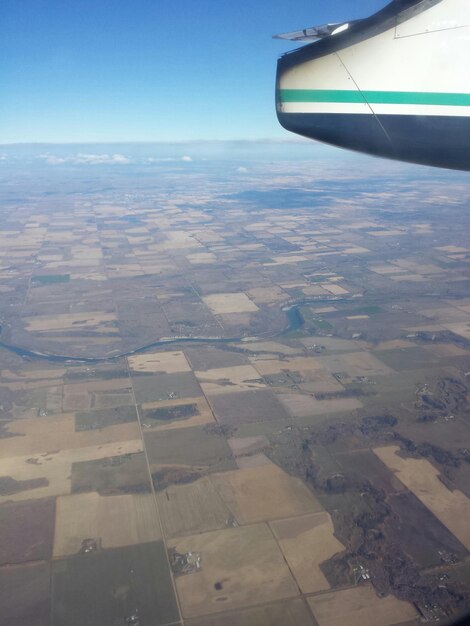 Cropped image of airplane wing over landscape